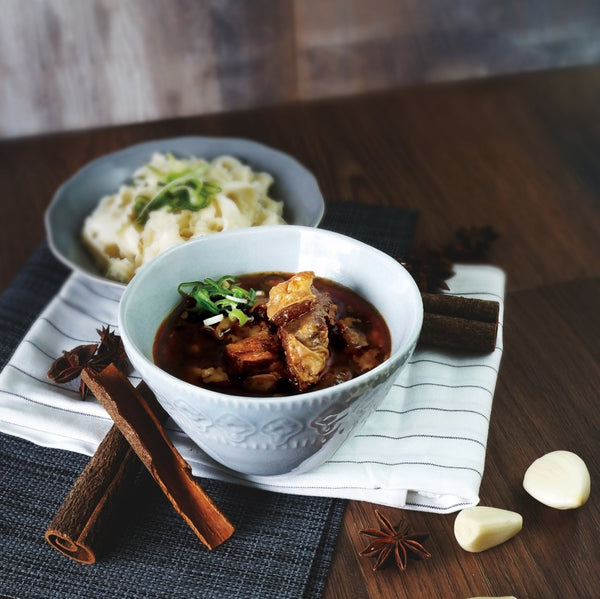 Han Dian ODD Beef Soup with Mashed Potatoes, Garnished with Green Onions on Wooden Table.
